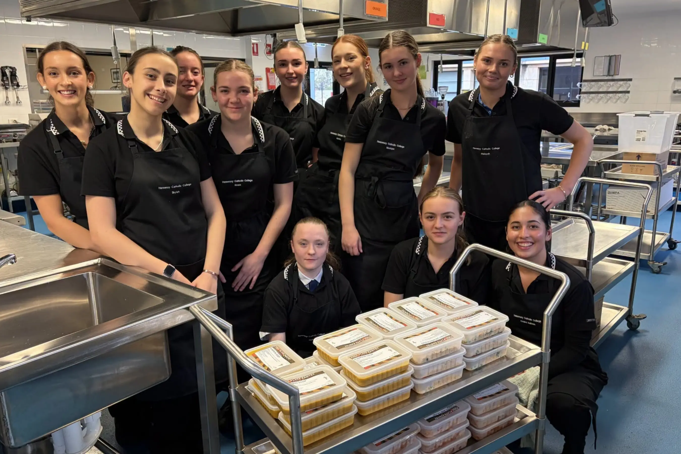 <p>Hennessy Catholic College students with meals prepared for the Full Plate Pantry \\u2013 Harvest and Hope initiative supporting the local community.</p>\\n