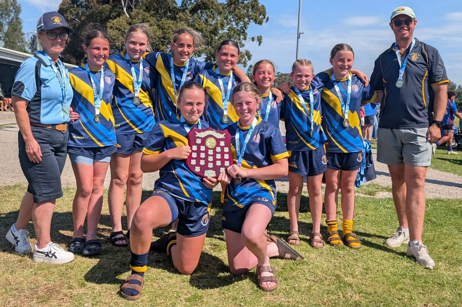 <p>The sevens team alongside coaches Ms Glover and Mr Shean after their win in Sydney. PHOTOS: Supplied</p>\\n